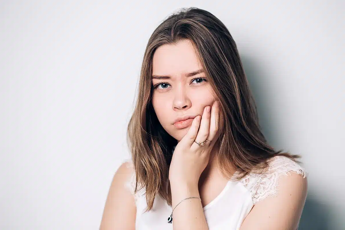 A Chomp Dental patient demonstrating the pain and discomfort of her wisdom teeth