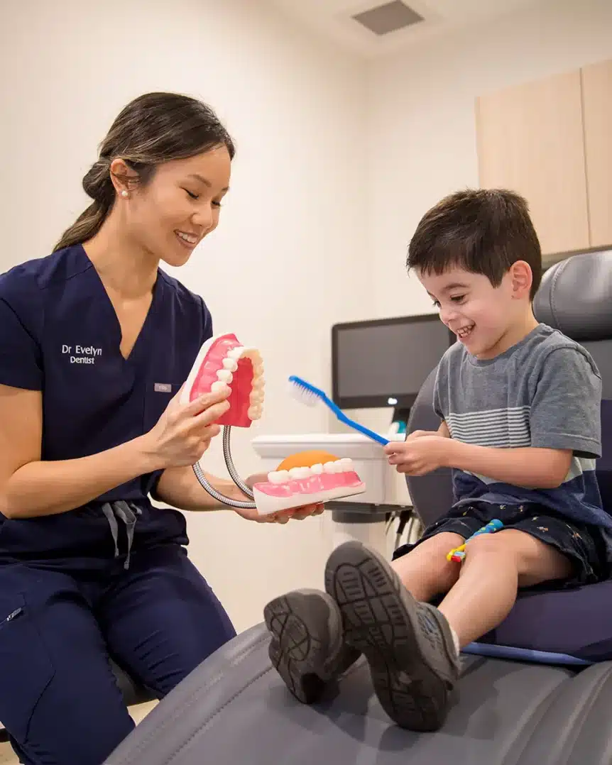The dentist at Chomp Dental is smiling as she plays with her child patient.