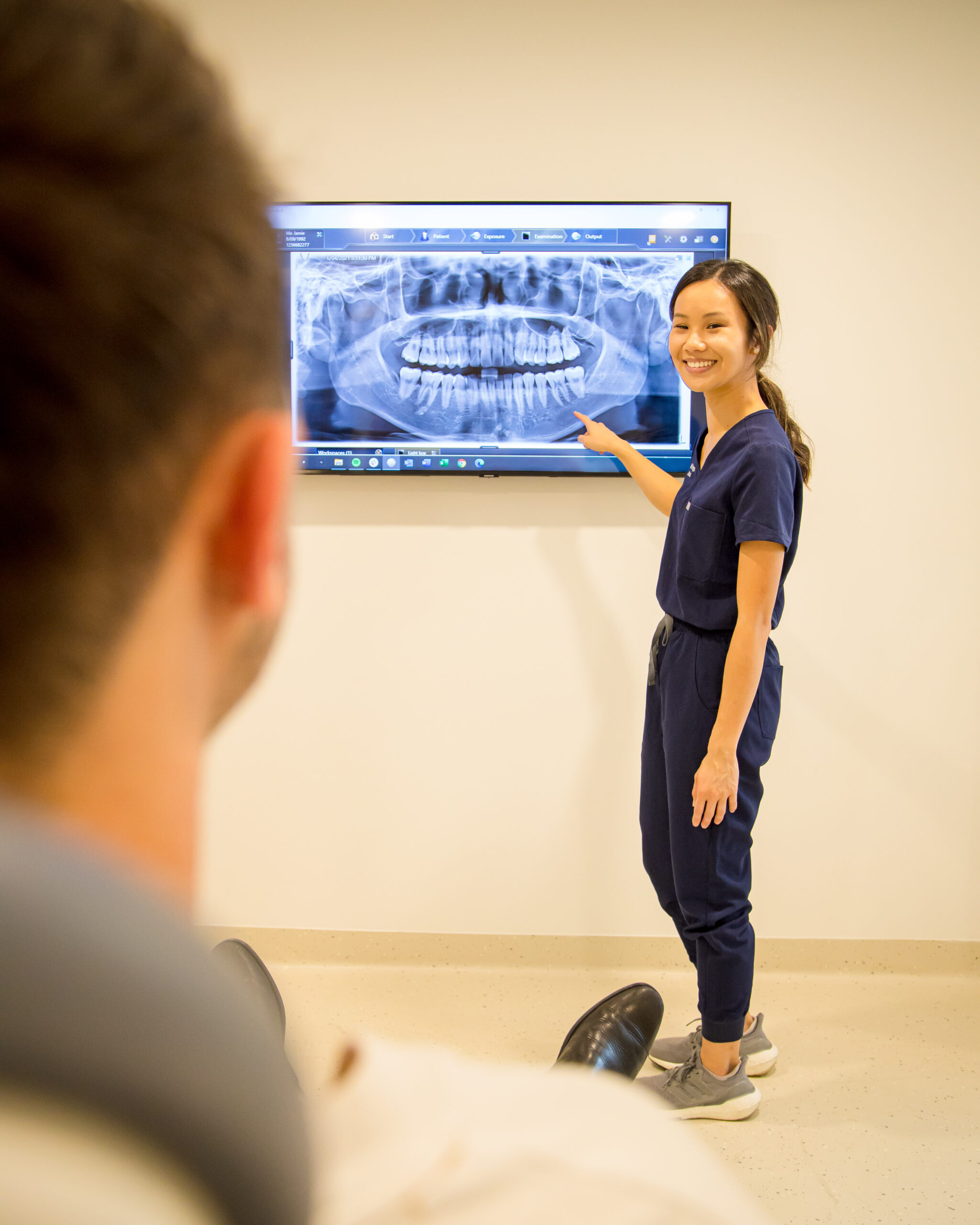 A Chomp Dental dentist explaining the x-ray result on the screen