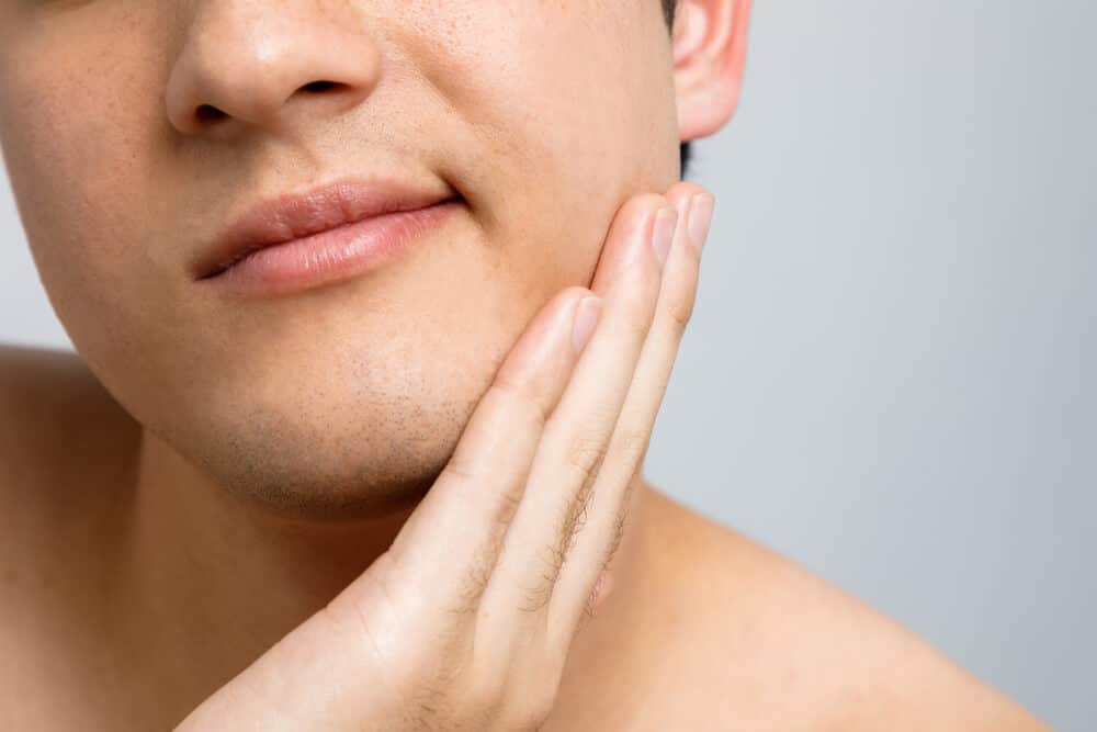 Close-up of a patient at Chomp Dental who is experiencing discomfort from a wisdom tooth